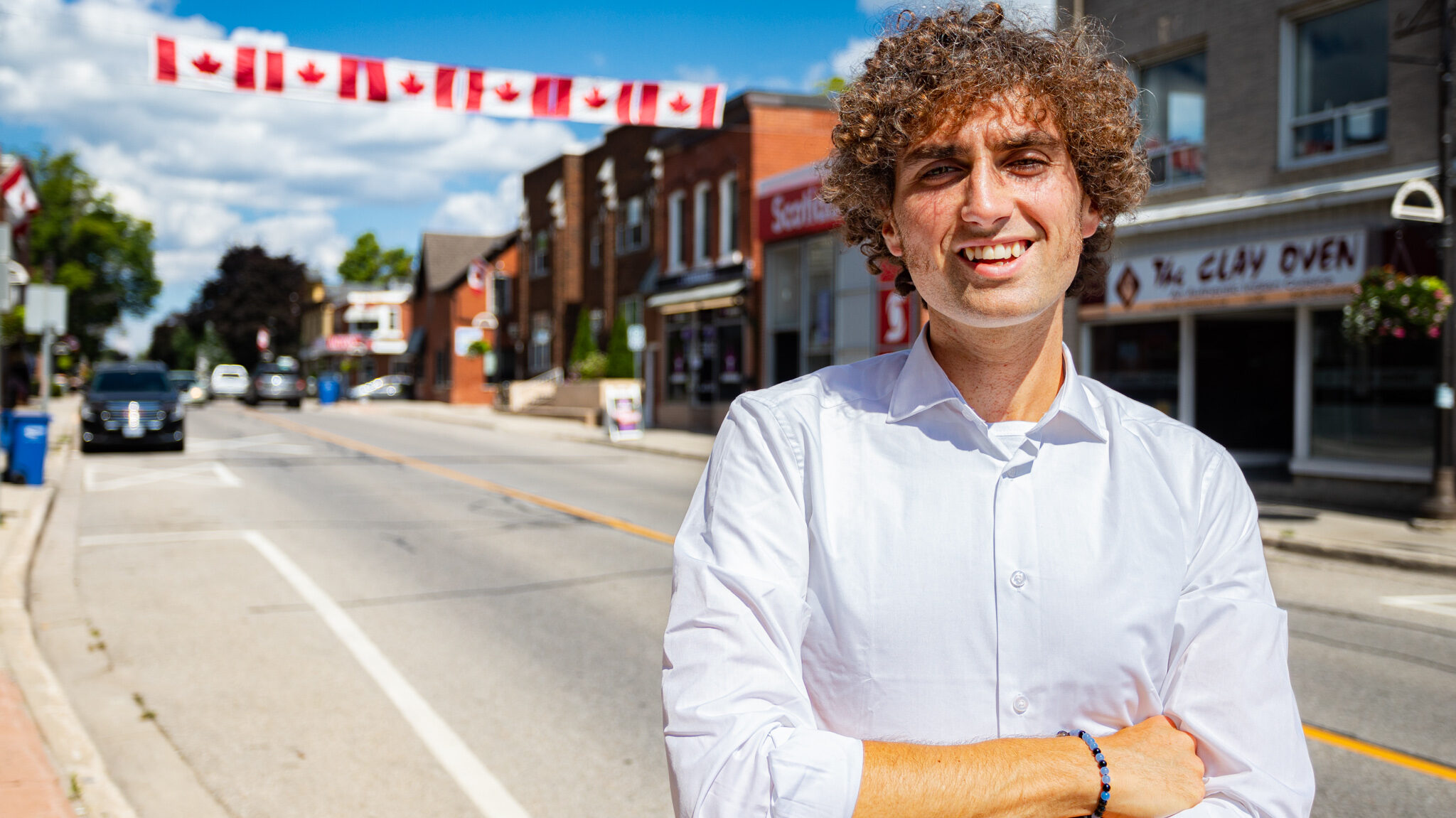 Featured image of Alex Hilson in front of iconic stores within the community of downtown Acton.